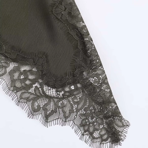 Detail of dark olive green satin dress featuring floral eyelash lace and micro-ribbed texture