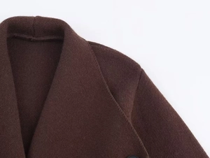 Gros plan sur la maille marron du cardigan avec détails du col et des coutures