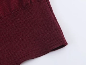 Close-up of burgundy knitted sleeve with ribbed cuffs and high-quality fabric texture