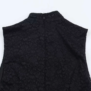 Detail of the mock neck and floral lace texture with hidden back zipper on black dress
