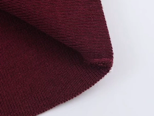 Macro shot showing detail of ribbed knit texture in wine red on women's long sleeve top