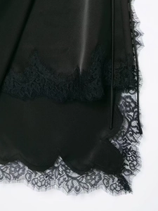 Detail of elegant black satin fabric with intricate eyelash lace trim and floral patterns