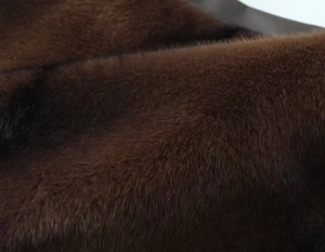 Detailed macro view of dark brown faux fur fabric texture for high-fashion skirts