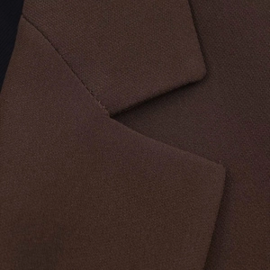 Macro shot of dark coffee blazer collar showing detailed woven fabric texture and stitching
