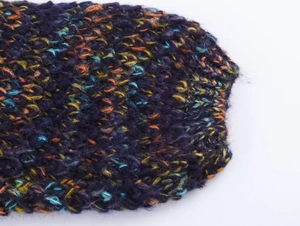 Close-up detail of multi-color mixed yarn chunky knit fabric with soft plush texture