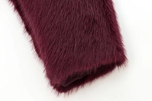 Macro shot of faux fur texture and smooth satin lining in deep purple winter jacket