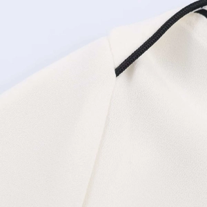 Detail shot of white chiffon top featuring contrast black woven drawstring and fine texture