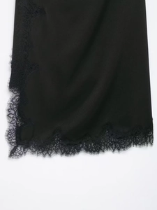 Detail showing high-quality black satin fabric and delicate eyelash lace trim on the hem