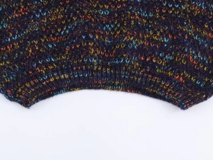 Macro detail of thick multicolor knit fabric with purple base and ribbed hem finish