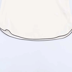 Detailed view of curved chiffon hem with contrast black piping and textured fabric
