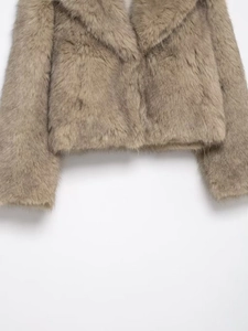 Detailed macro texture of warm beige faux fur coat with a soft stylish lapel collar