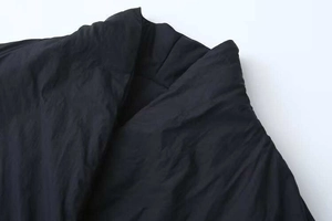 Detail of black double-breasted coat collar with matte texture and durable nylon fabric