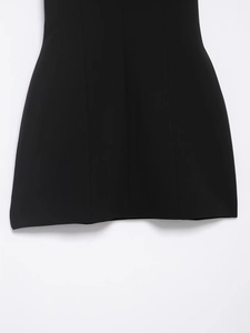 Detailed view of the black dress hemline featuring vertical seams and a subtle A-line silhouette