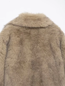 Detailed macro view of plush brown faux fur collar and back with thick, glossy texture