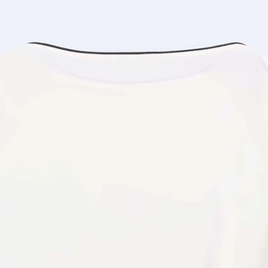Detail of the white chiffon top showing the minimalist black contrast binding neckline