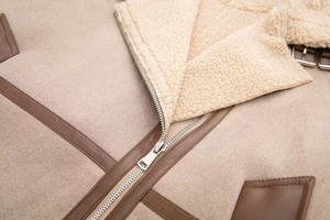 Close-up of winter jacket featuring faux shearling lining, suede fabric and metal zipper detail