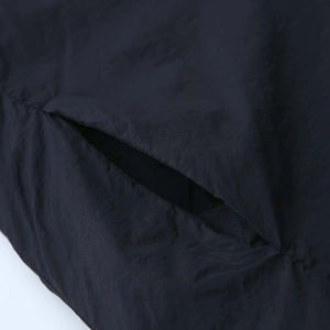 Detailed close-up of pocket stitching and lightweight fabric texture on black kimono coat