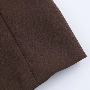 Detailed macro view of high-quality dark brown knitted fabric and precision stitching line
