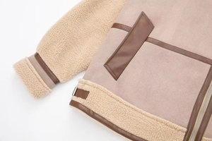 Detail of winter jacket showing faux suede, fleece panels and dark brown leather piping