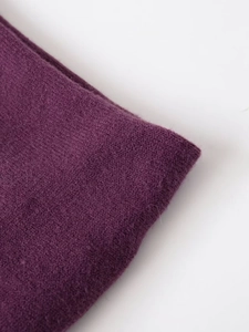 Detail shot of deep purple knitted wool fabric with soft brushed texture and fine stitching