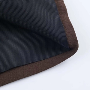 Close-up of deep brown woven fiber texture and black inner lining of this blazer jacket