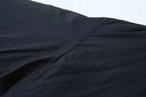 Detail of flat seam stitching on a long-sleeved casual black kimono jacket