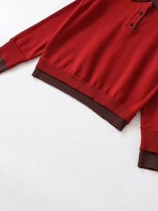 Detail of red knit polo sweater with dark brown contrast trim and buttoned collar