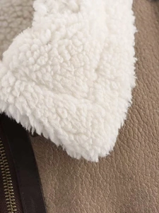 Detail shot of brown faux leather texture and white sherpa lining on a jacket