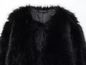 Detailed macro view of the black faux fur collar with premium plush texture and brand label
