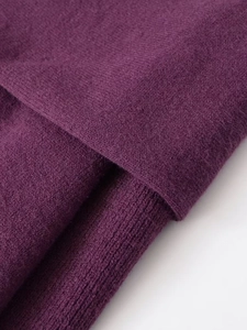 Detailed macro shot of dark purple knitted fabric texture showing soft brushed wool fiber