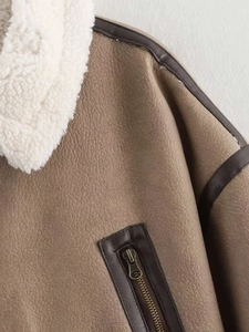 Detail of brown faux suede jacket with white sherpa collar and bronze metal zipper