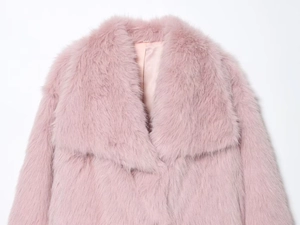 Détail du manteau en fausse fourrure rose montrant le col et la doublure en satin
