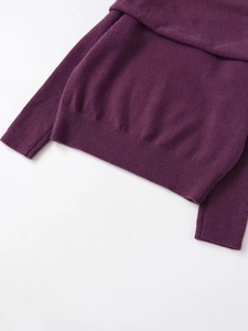 Close-up detail of dark purple knit sweater showing soft ribbed hem and cuff texture