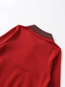 Detail of red knit sweater with contrasting brown polo collar and fine needlework