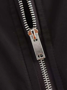Detail of silver metal zipper on premium black oversized varsity jacket fabric