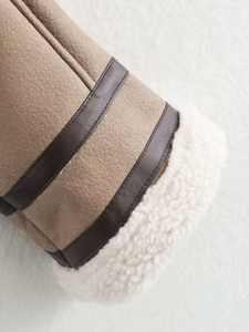 Close-up of winter jacket cuff showing faux suede fabric and warm white shearling lining