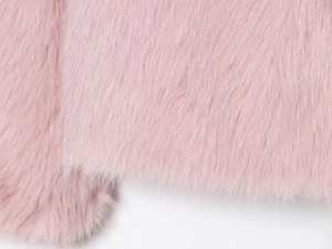 Gros plan sur la texture de fausse fourrure rose doux aux fibres longues et denses