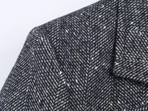 Detailed macro view of the herringbone pattern on a black and white wool blazer