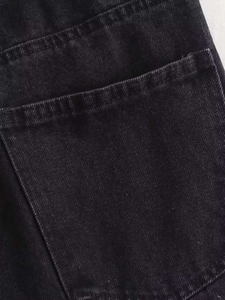 Close-up of black denim fabric showing high-quality stitching and back pocket texture