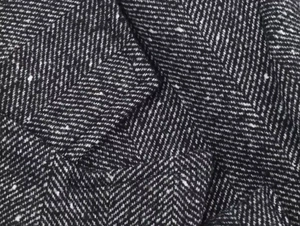 Macro shot of black and white herringbone wool fabric texture for short blazer coats