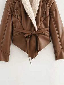 Detail of brown faux leather jacket with white shearling trim and waist tie design