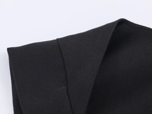 Detail of black square neck romper showing high-density knitted fabric and neat stitching
