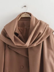 Detail of dark camel wool coat featuring a built-in scarf neck and matching buttons