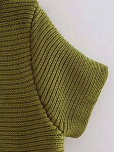 Dettaglio ravvicinato del tessuto a maglia a coste verde muschio e della sua trama
