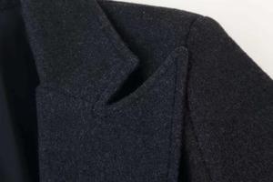 Dettaglio macro del cappotto di lana grigio antracite con bavero e cucitura spalla