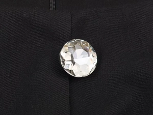 Close-up of faceted crystal button detail on black square neck romper for women