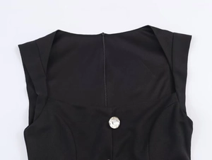 Detail of square neckline with crystal button and hidden zipper on black romper