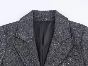 Detail of herringbone tweed texture on blazer lapel with high-quality wool blend fabric