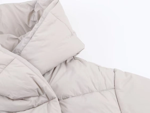 Close-up of light gray quilted puffer jacket showing premium insulation and fabric texture
