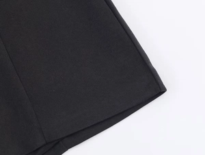 Close-up of the high-quality woven fabric hem and precision stitching of the black jumpsuit